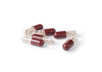 Capsules with granules on white background. Digestive pills with pancreatin ingredient. Macro shot. Close up, no shadows.