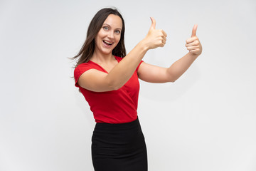 Portrait to the waist of a young pretty brunette woman of 30 years old in a bright red sweater with beautiful dark hair. Standing on a white background, talking, showing hands, with emotions