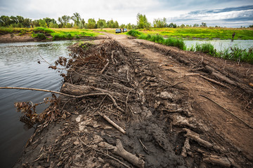 Temporary road - a dam across the river Meret (Mereda). Western Siberia