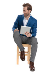 Positive casual guy laughing and holding his table