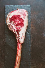 Top view of raw dry-aged marble beef steak Tomahawk. Flat lay, cooking concept.