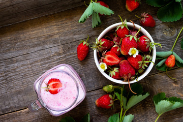 Fototapeta na wymiar Dietary breakfast for summer time, vegan food concept. Fresh Strawberry milkshake on rustic wooden table. Free space for your text. Top view flat lay background.
