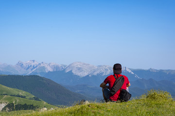 Naklejka na ściany i meble man admiring the landscape, sitting on a top of the Pyrenees mountain range