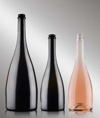 three champagne bottles on grey background