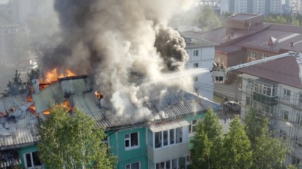 firefighters extinguish a fire on the roof of a residential highrise building. top view