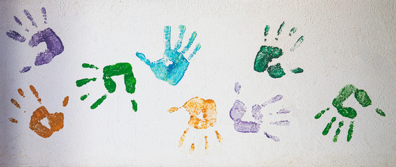 Marcas coloridas de mãos na parede