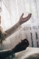 Hands holding a veil. lifts the veil. Morning. Stylish dress. close up. background white