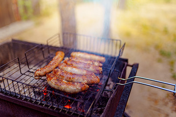 Grilled sausage on the picnic flaming grill outdoor
