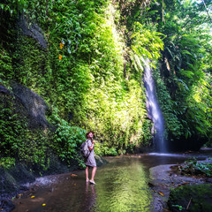 Woman near waterfal on Bali, Indonesia 