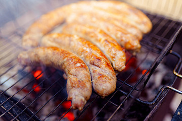 Grilled sausage on the picnic flaming grill outdoor