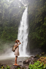Fototapeta na wymiar Woman near Nung Nung waterfal on Bali, Indonesia