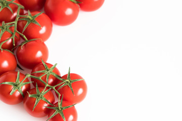 Branch of a fresh red tomato cherry, isolated on a white background corner composition