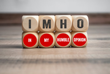 Cubes and dice with term IMHO In My Humble Opinion on wooden background