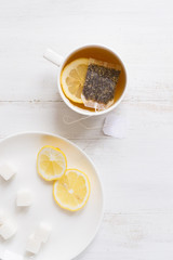 Tea with lemon on white wooden table
