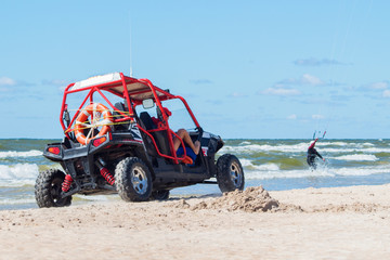 rescuers on the Buggy ride on the beach and watch the kite surfer