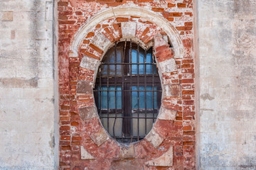 background of oval window with bars in an old brick building close up with copy space