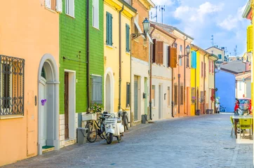 Abwaschbare Fototapete Scooter Typische italienische Altbauten mit farbenfrohen, bunten Wänden und traditionellen Häusern und Motorradrollern, die auf der Kopfsteinpflasterstraße im historischen Stadtzentrum von Rimini, Emilia-Romagna, Italien, geparkt sind