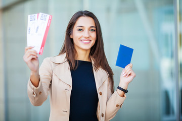 Travel. Woman holding two air ticket in abroad passport near airport