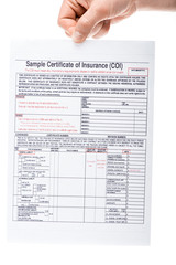 cropped view of man holding insurance certificate isolated on white