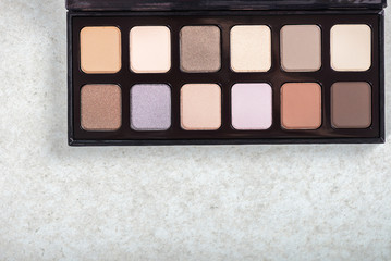 Neutral color eye shadows palette on grey background