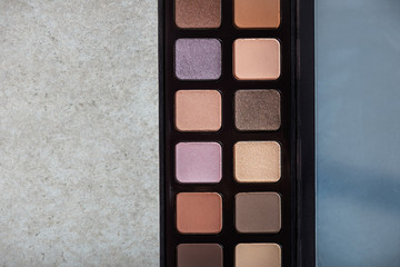Neutral color eye shadows palette on grey background
