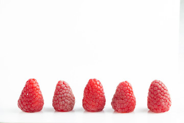 five ripe beautiful raspberry berry on a white background