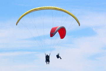 paragliders in a blue sky