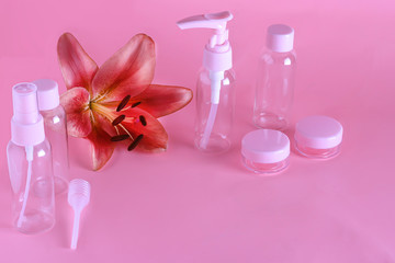 Cosmetic travel set. Various cosmetic bottles on a gently pink background with a copy space. A collection of cosmetic packaging for cream, soap, foam, shampoo.