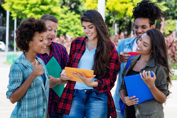 Studentin mit langen dunklen Haaren lernt mit internationalen Studenten