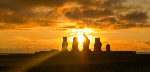 Obraz premium LENS FLARE: Golden sunset illuminates a row of moai statues on Easter Island.