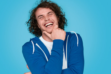 Cheerful male rubbing chin