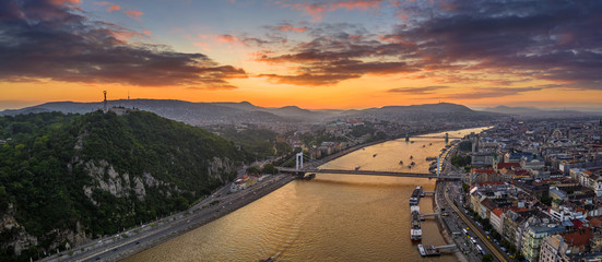 Fototapeta premium Budapest, Hungary - Aerial panoramic skyline view of Budapest with Elisabeth Bridge, Szechenyi Chain Bridge, Buda Castle Royal Palace, Gellert hill and Statue of Liberty and a dramatic colorful sunset