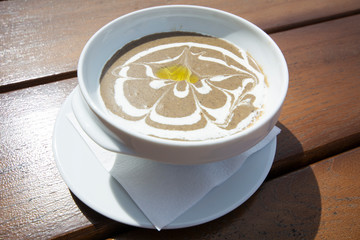 Delicious mushroom cream soup with croutons on a wooden table