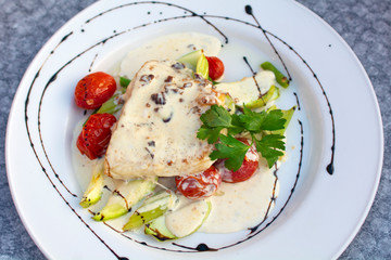 Pike perch fillet with creamy nut sauce with zucchini and grilled tomatoes