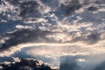 in the sky, the sun's rays pass through the clouds