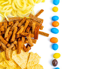 Assortment of Unhealthy Snacks: chips, onion rings, crackers top view, flat lay. Unhealthy eating concept.