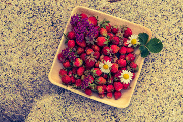 Fresh red strawberries in a wooden plate. Strawberry is a source of vitamin C. This berry is a...
