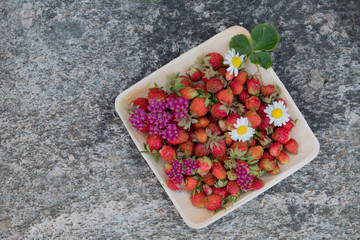 Fresh red strawberries in a wooden plate. Strawberry is a source of vitamin C. This berry is a...
