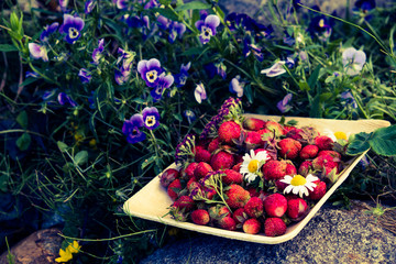 Fresh red strawberries in a wooden plate. Strawberry is a source of vitamin C. This berry is a...