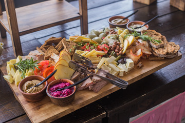 Buffet of assorted cheese cured meat, sausage, ham, fruit, vegetables, olives, pickled, bread and sauce for the event or party.