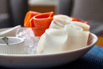 Stroganina, a traditional dish in Siberia. Raw frozen fish sliced into thin slices. Eat with salt, pepper and sauce.