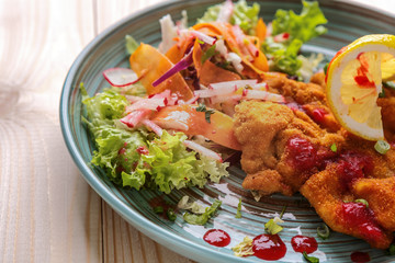 Meat in batter with vegetables on a plate