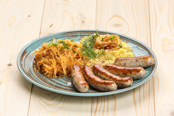 Fried sausages with mashed potatoes, fried cabbage and onions
