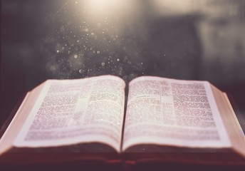 Open old book on wooden table.