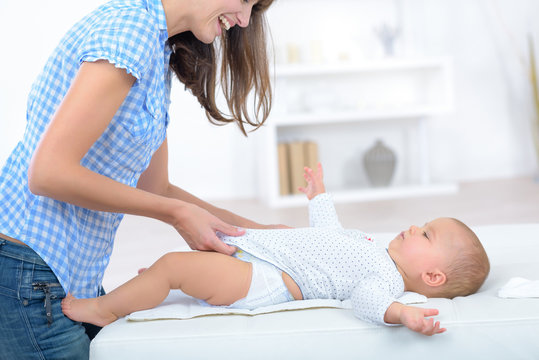 Mother Dressing Baby After Changing Nappy