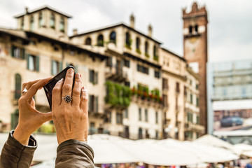 mature tourist taking photo of Verona