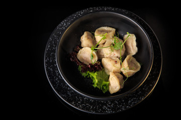 top view on ready russian pelmeni served with salad in bowl