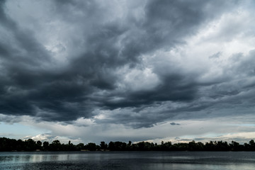 Fototapeta na wymiar Dark stormy clouds before thunder storm over the river