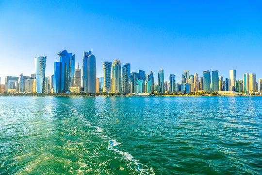 Cityscape of Doha West Bay skyline from boat trip in Doha Bay at sunset light, Doha, Qatar