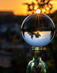 Nice sunset in reflection of the glass balloon in orange tones with the sun rays